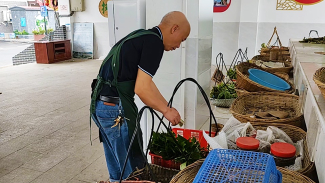 在福建永定不見賣主的自助菜攤，附近居民在挑選蔬菜。永定區(qū)委組織部供圖