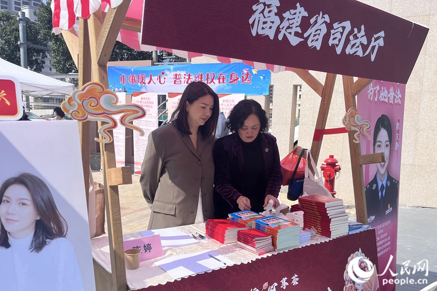 “蒲公英”普法志愿者向群眾發(fā)放婦女權(quán)益保障法等法律及普法宣傳書籍。人民網(wǎng) 錢嘉禾攝