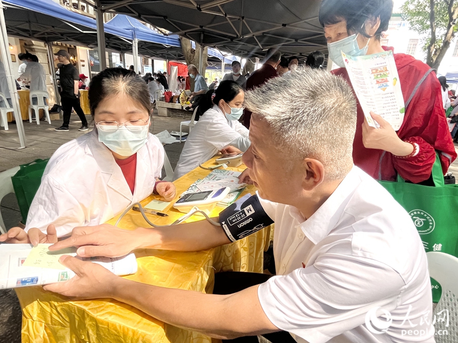 一位市民在展位前測量血壓。人民網(wǎng) 錢嘉禾攝