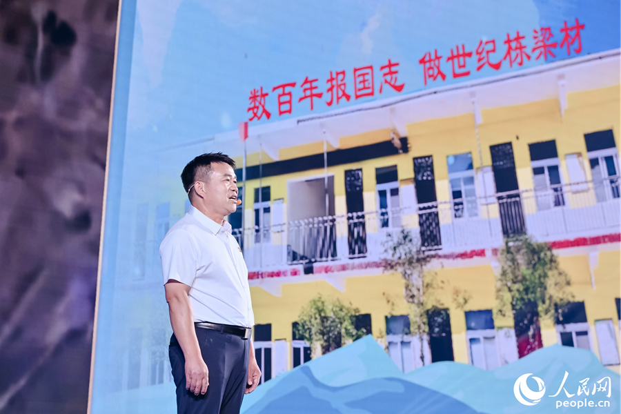 張玉滾分享用一根扁擔(dān)送孩子們走出大山的故事。人民網(wǎng)攝