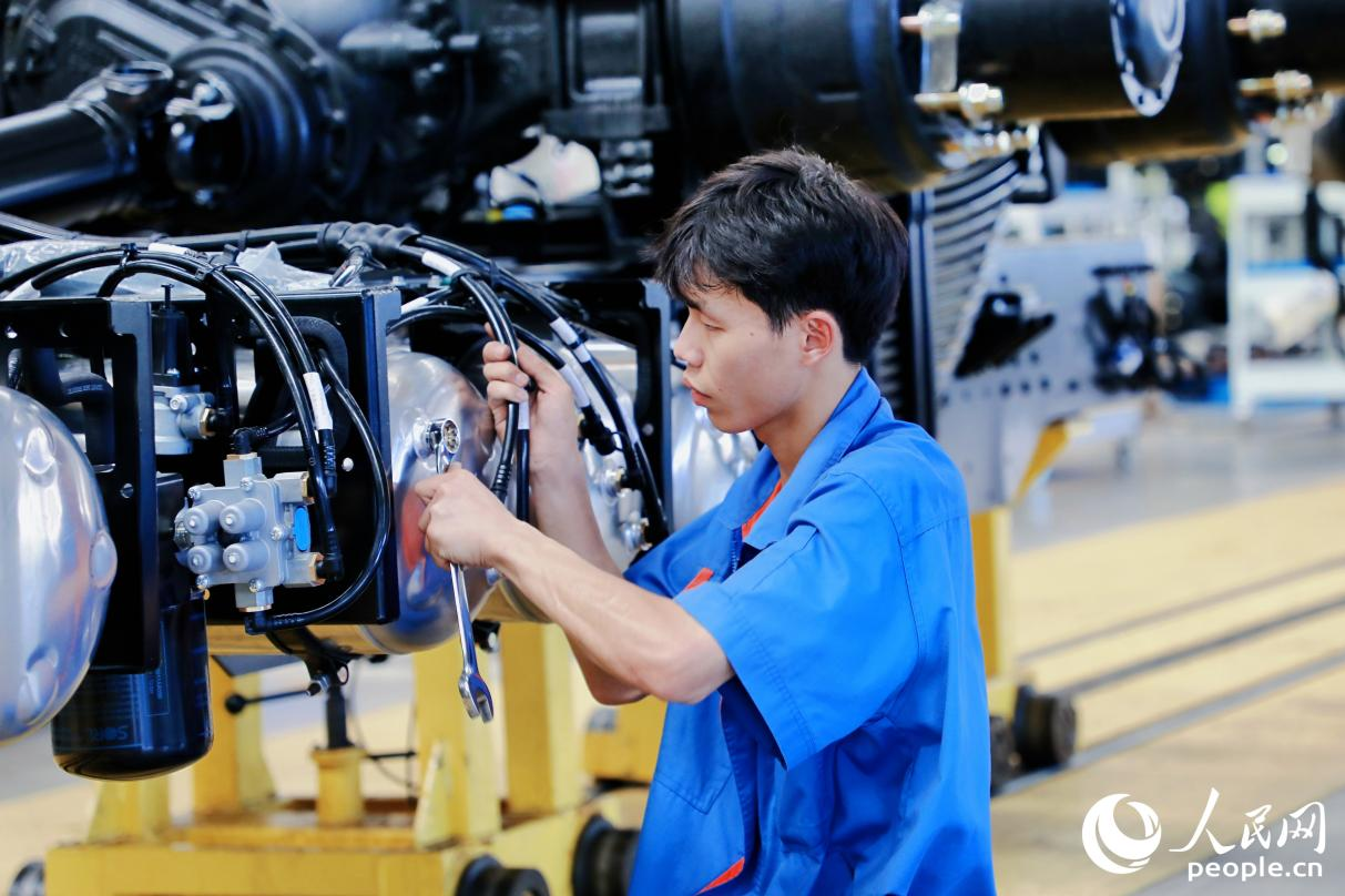 工人將整車底盤的螺絲釘擰緊。人民網 李唯一攝