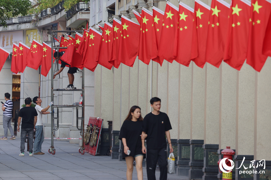工作人員將一面面五星紅旗整齊有序地插上騎樓。人民網(wǎng)記者 陳博攝