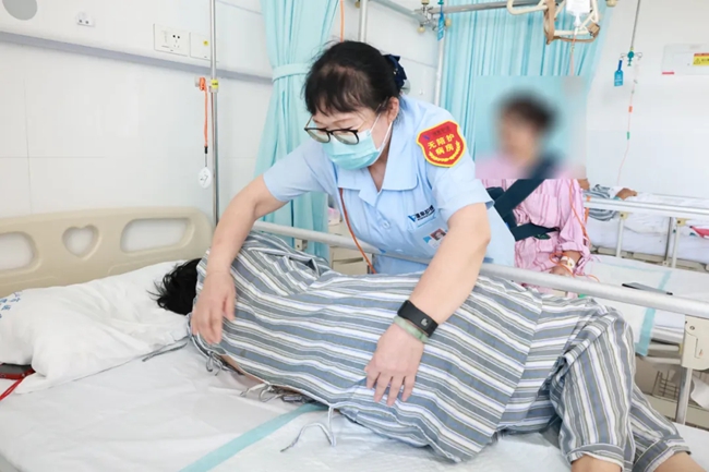 護理員協(xié)助患者翻身