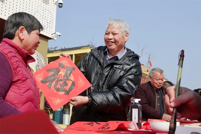寫贈春聯(lián)。張九強攝