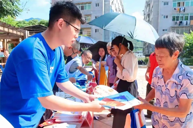 “法小穗”青年志愿者為群眾發(fā)放普法宣傳冊(cè)
