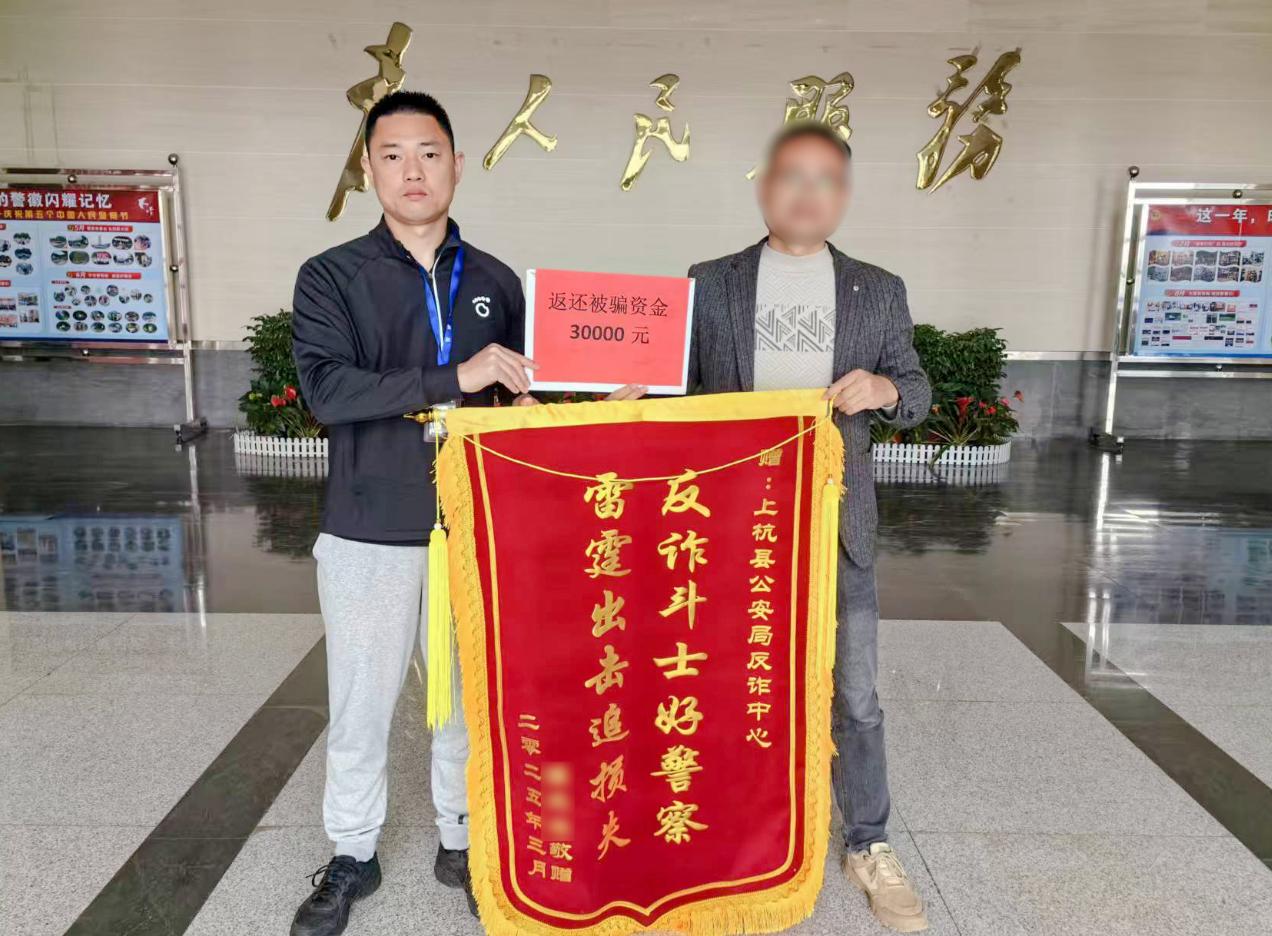 群眾送錦旗致謝民警追回被騙資金。羅龍輝攝