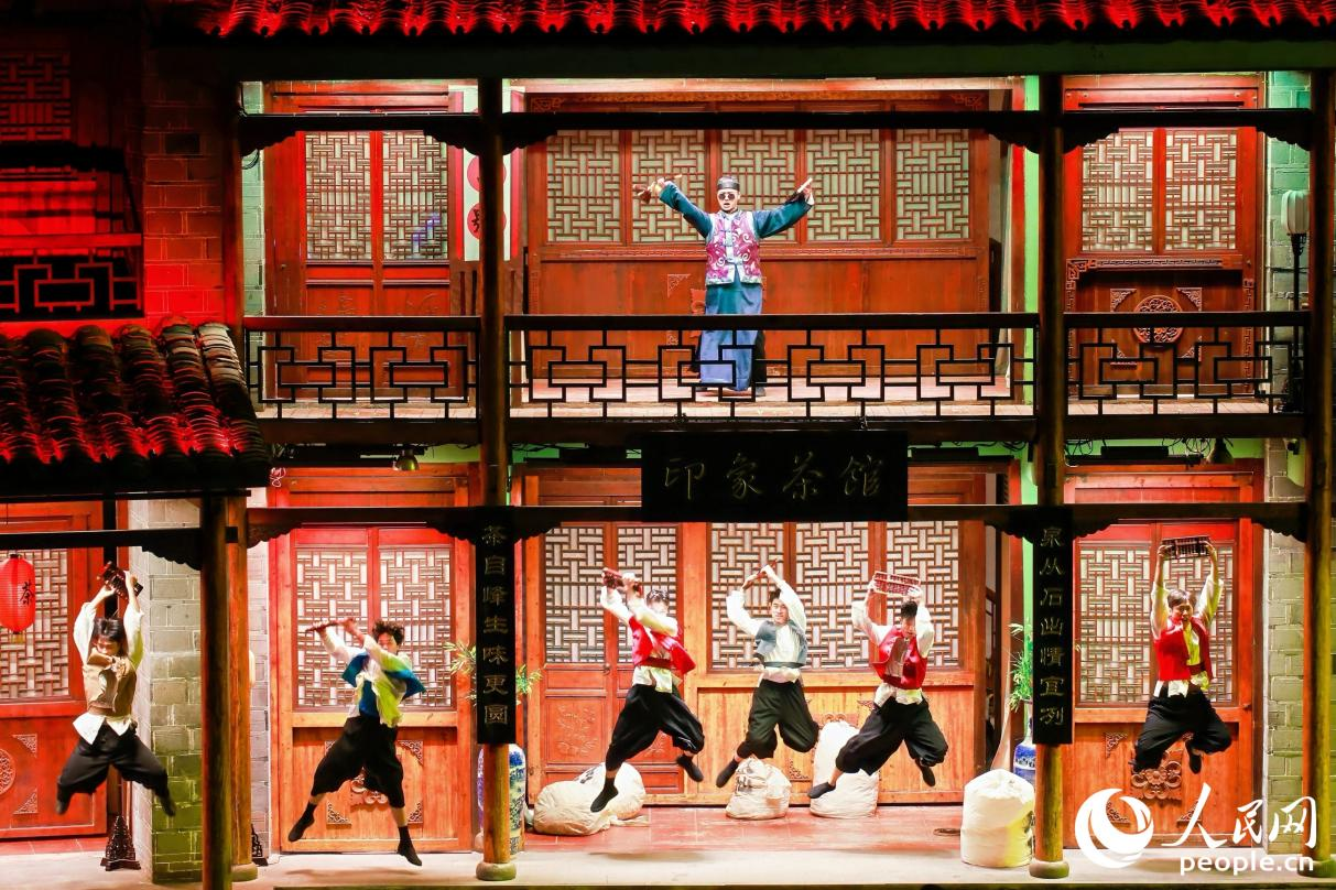王龍濤（上）飾演茶掌柜帶領(lǐng)茶廠的伙計(jì)，為五湖四海的茶商計(jì)算“武夷四大名樅”的價格。人民網(wǎng) 李唯一攝