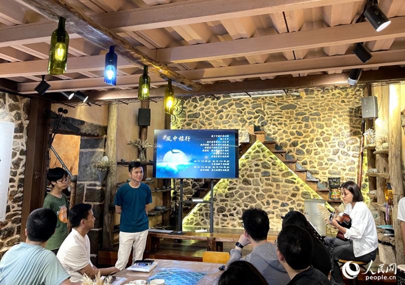 風(fēng)中旅行文創(chuàng)工坊里，主理人正在用歌聲歡迎遠(yuǎn)道而來的客人。人民網(wǎng)記者 陳藍(lán)燕攝