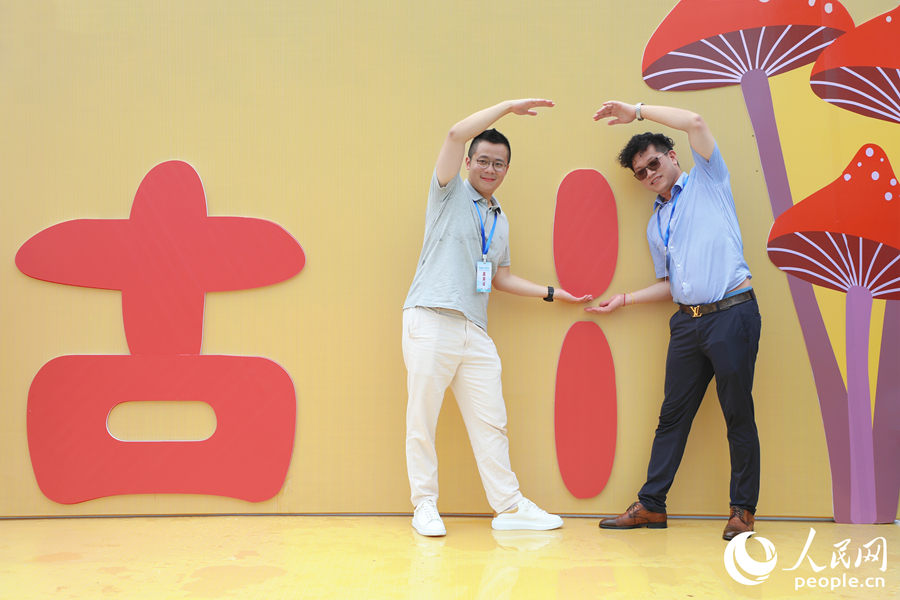 兩位游客在展區(qū)打卡點用肢體拼湊成古田的“田”字。人民網 李唯一攝