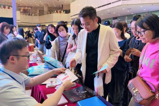 現(xiàn)場觀眾排隊領(lǐng)取集友銀行支票明信片周邊