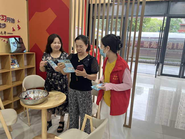 網(wǎng)格員在黨群暖心驛站內(nèi)為群眾宣傳醫(yī)保政策