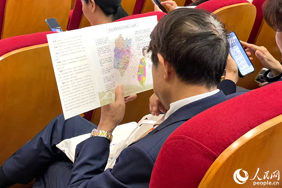 一位嘉賓認(rèn)真端詳姓氏入閩及遷臺(tái)示意圖。人民網(wǎng)記者 林盈攝