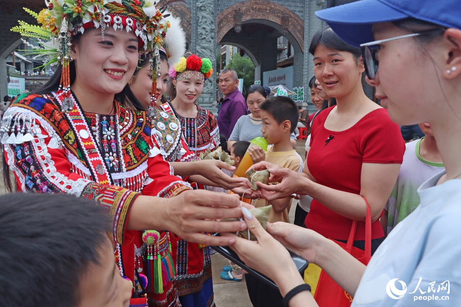 為游客免費派發(fā)“烏米粽”。人民網(wǎng) 李昌乾攝