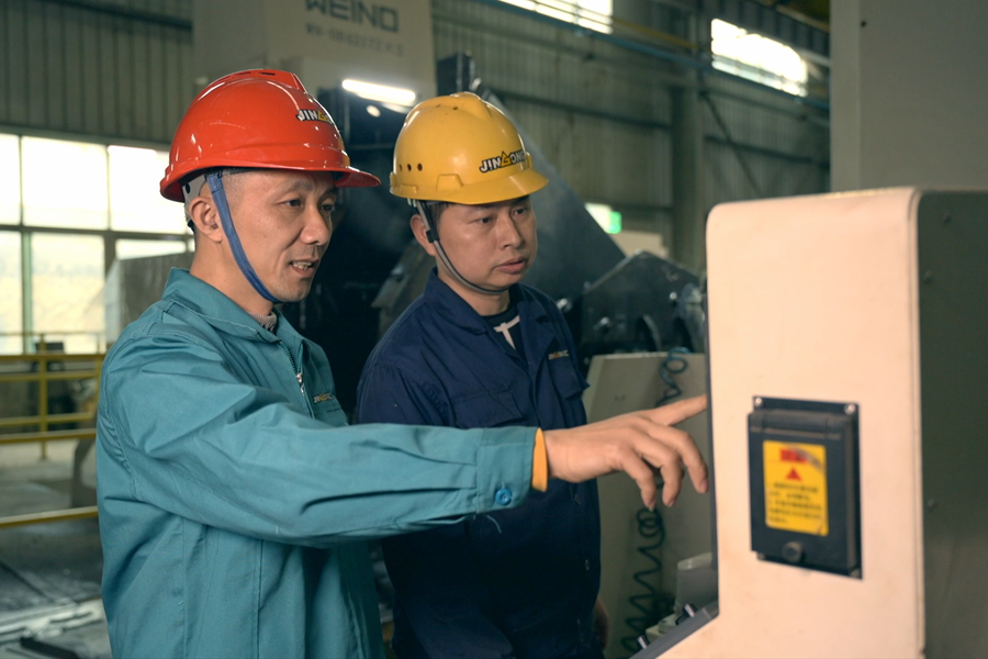 張達斌（左一）在車間指導操作。福建開放大學供圖