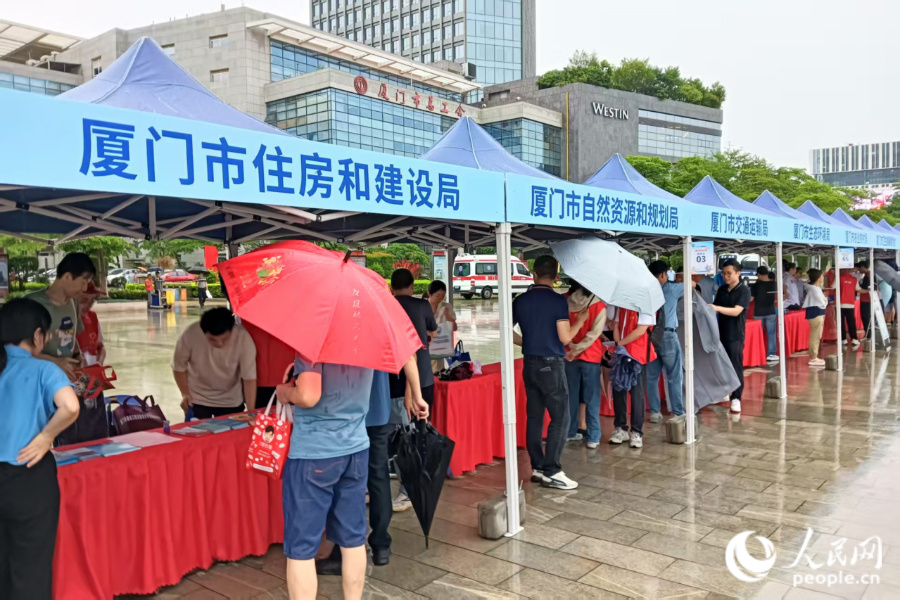 雖然大雨滂沱，但46家參與單位的工作人員依然熱情滿滿，為前來咨詢的市民群眾耐心解答問題。人民網(wǎng)記者 陳博攝