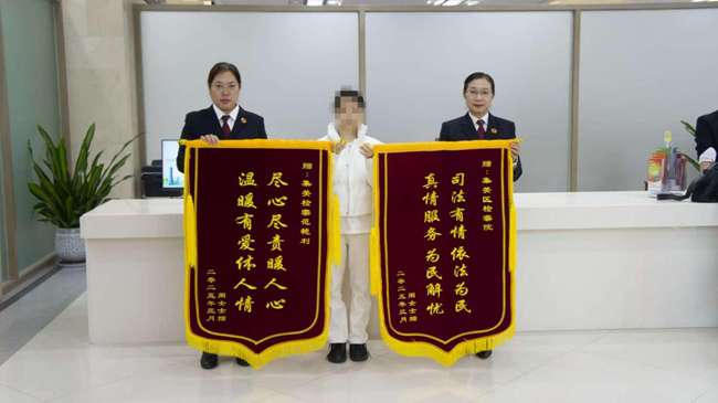 周女士贈(zèng)錦旗向檢察官表達(dá)謝意。集美檢察供圖