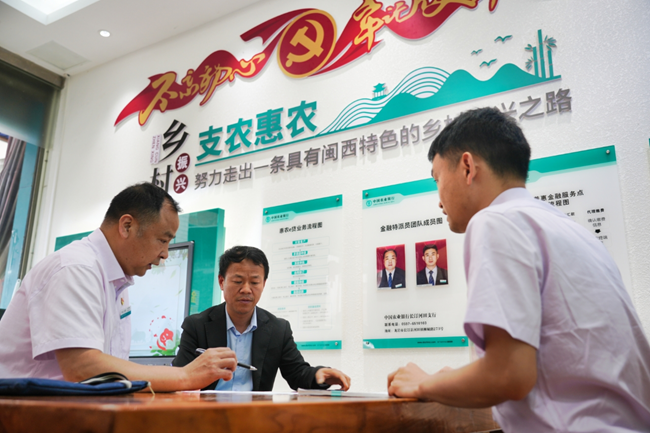 農(nóng)行工作人員在“惠農(nóng)服務(wù)旗艦店”暨“李文慰勞模工作室”向農(nóng)戶介紹農(nóng)戶貸款