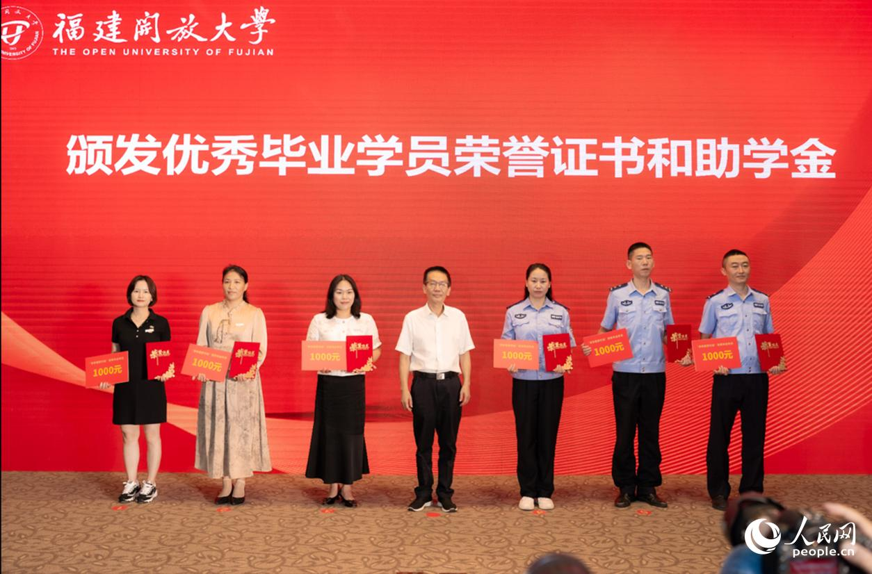 福建省總工會副主席方月興為勞模本科班優(yōu)秀畢業(yè)學員代表頒發(fā)榮譽證書和助學金。實習生 魏建燁攝