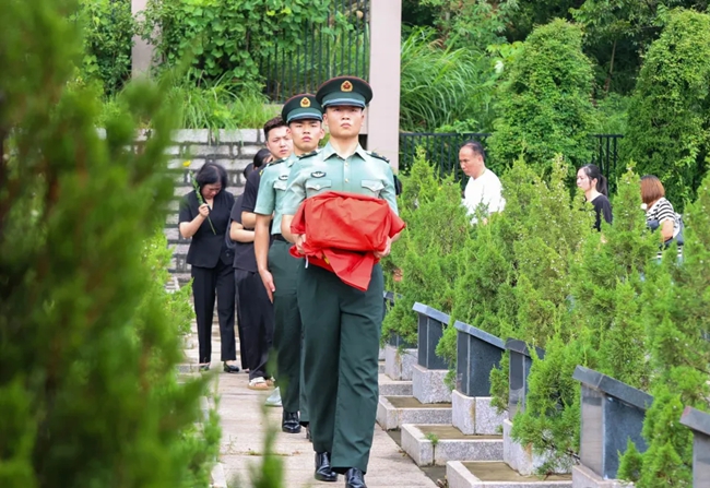 禮兵雙手托舉烈士棺槨，護(hù)送至墓位