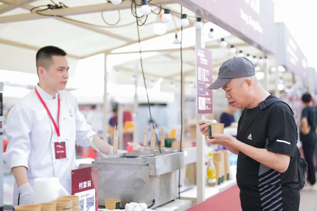游客在攤位前品嘗美食