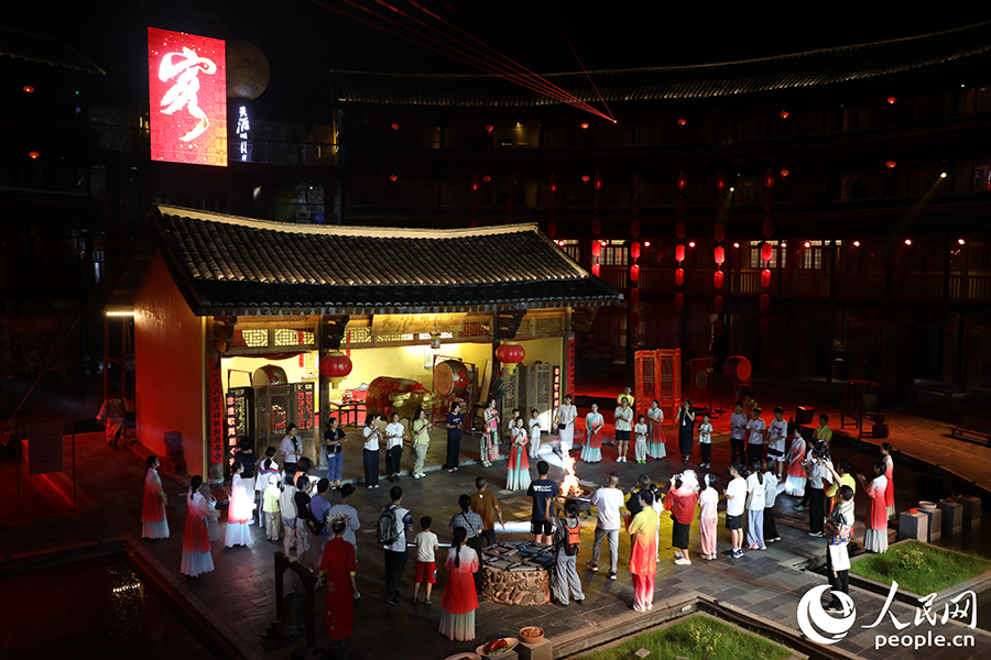 游客登上“土樓舞臺”與演員同臺互動。人民網(wǎng) 李唯一攝