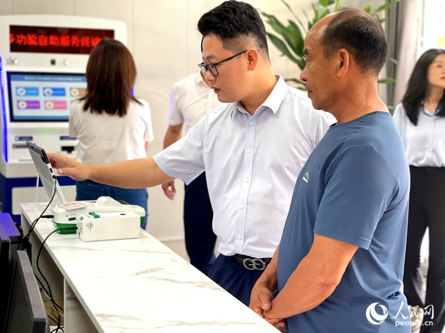 市民正在現(xiàn)場工作人員協(xié)助下辦理社保卡。人民網(wǎng)記者 陳藍燕攝