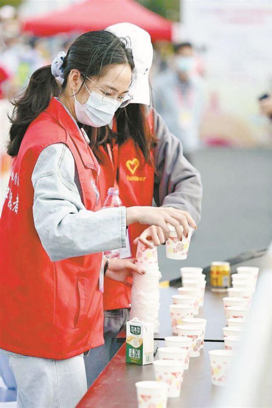 廈馬賽道旁，文明志愿者為參賽選手提供志愿服務(wù)。廈門市委文明辦供圖